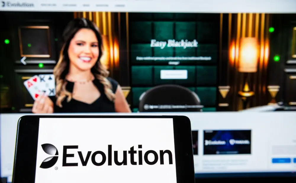 Evolution Gaming Logo auf einem Smartphone vor der Evolution Website.